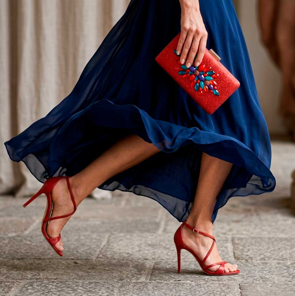 Vestido azul marino con zapatos y bolso rojo